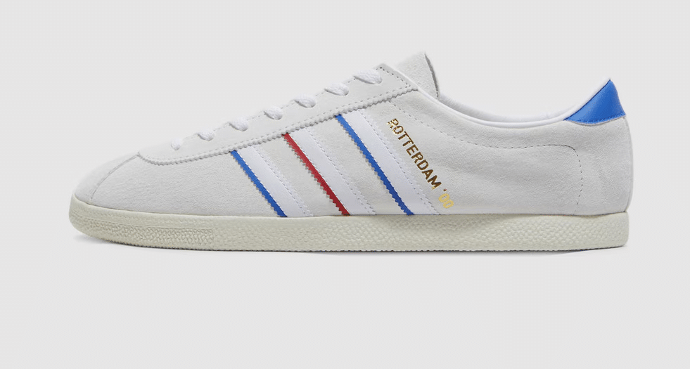 White and blue suede Adidas Rotterdam '80 sneakers with red stripes.