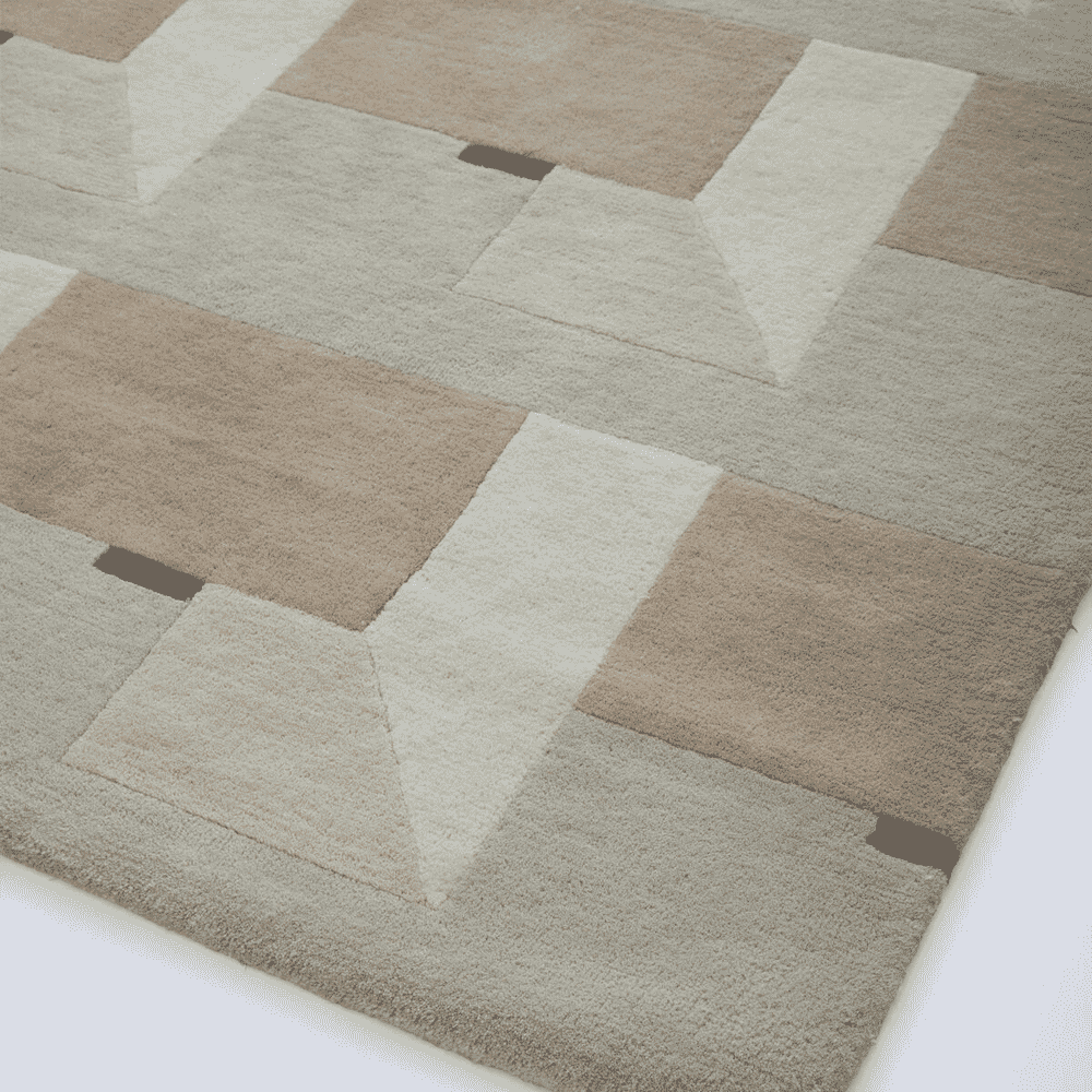 Close-up of a textured wool pile rug with a beige and taupe geometric block design.