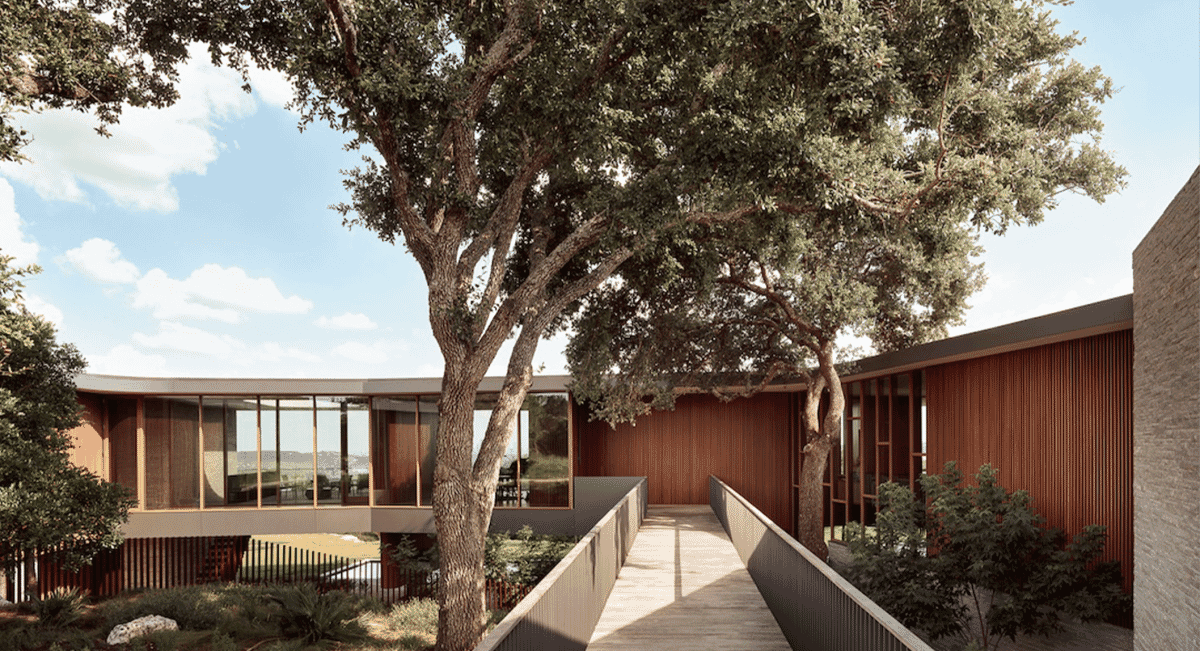 Modern residence with a wooden walkway and large trees.