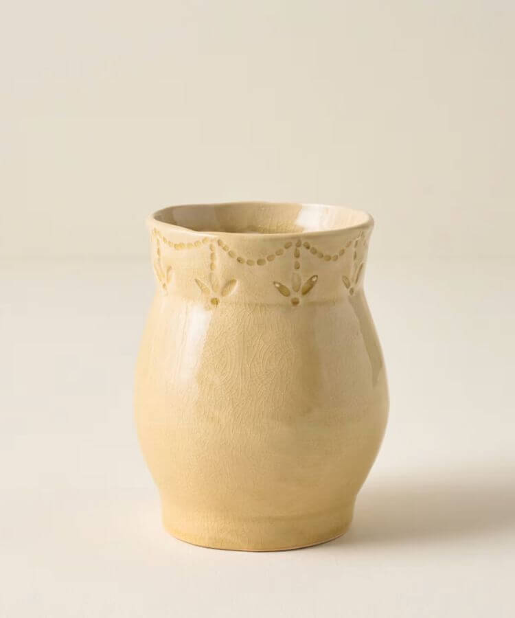 Ceramic vase with subtle floral glazed patterns in yellow.
