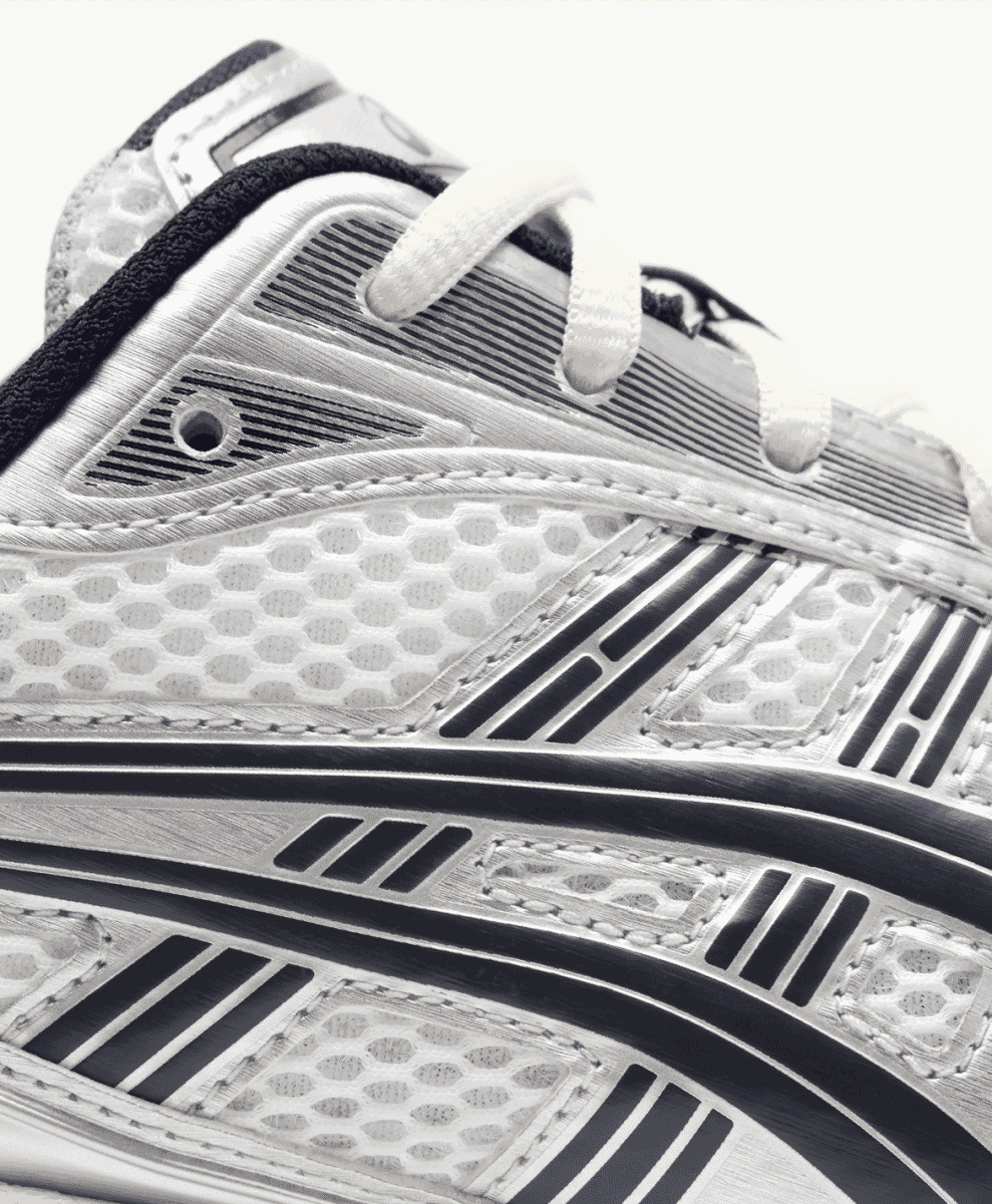 Close-up of the technical mesh and striped overlays on the black and silver sneaker.