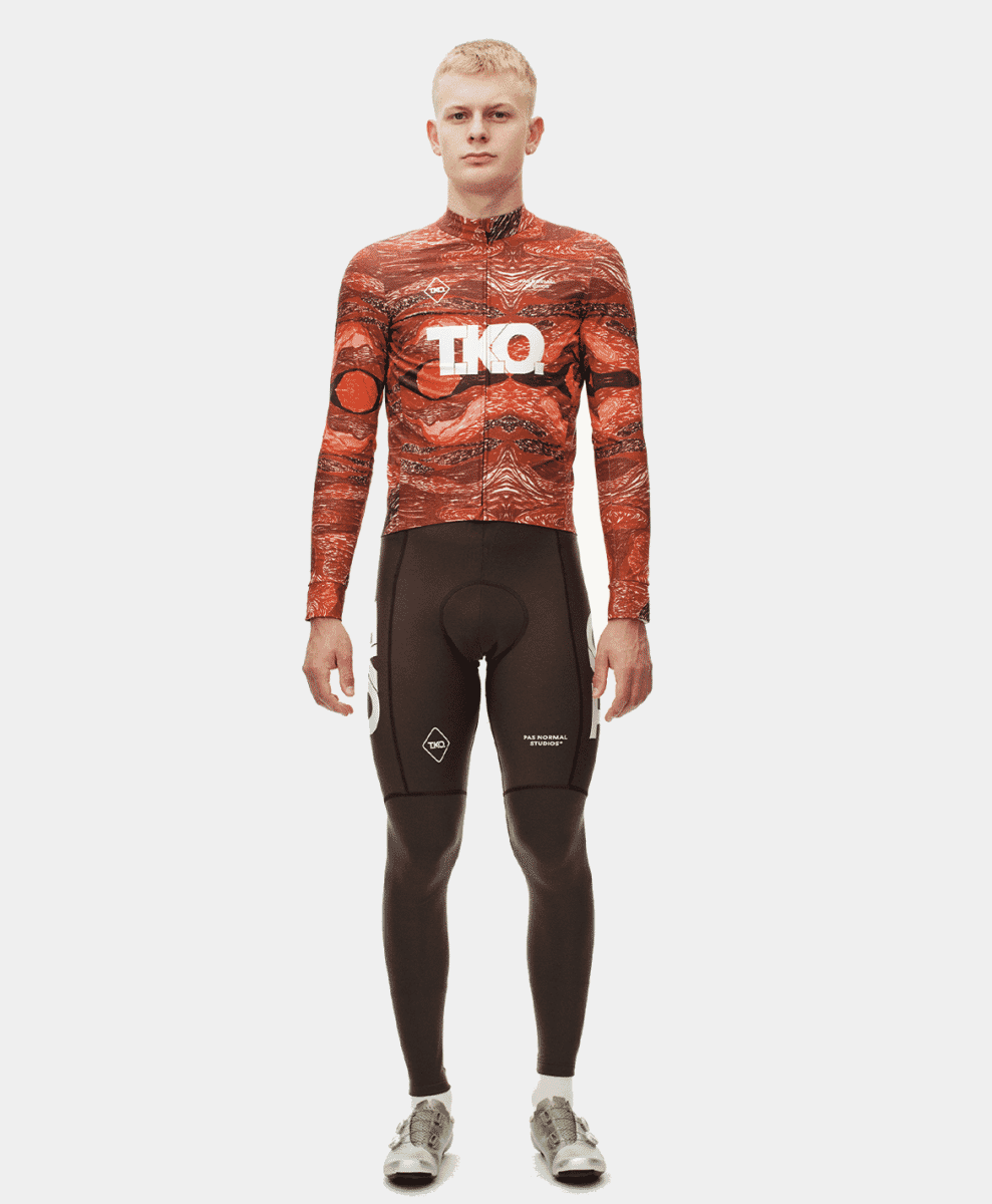 Male model in a vibrant orange and black marbled long-sleeve cycling jersey.