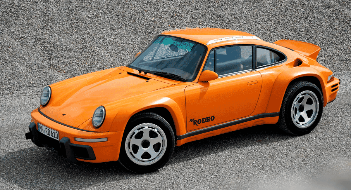 Front view of an orange Porsche Rodeo sports car on gravel showcasing its retro-modern design.