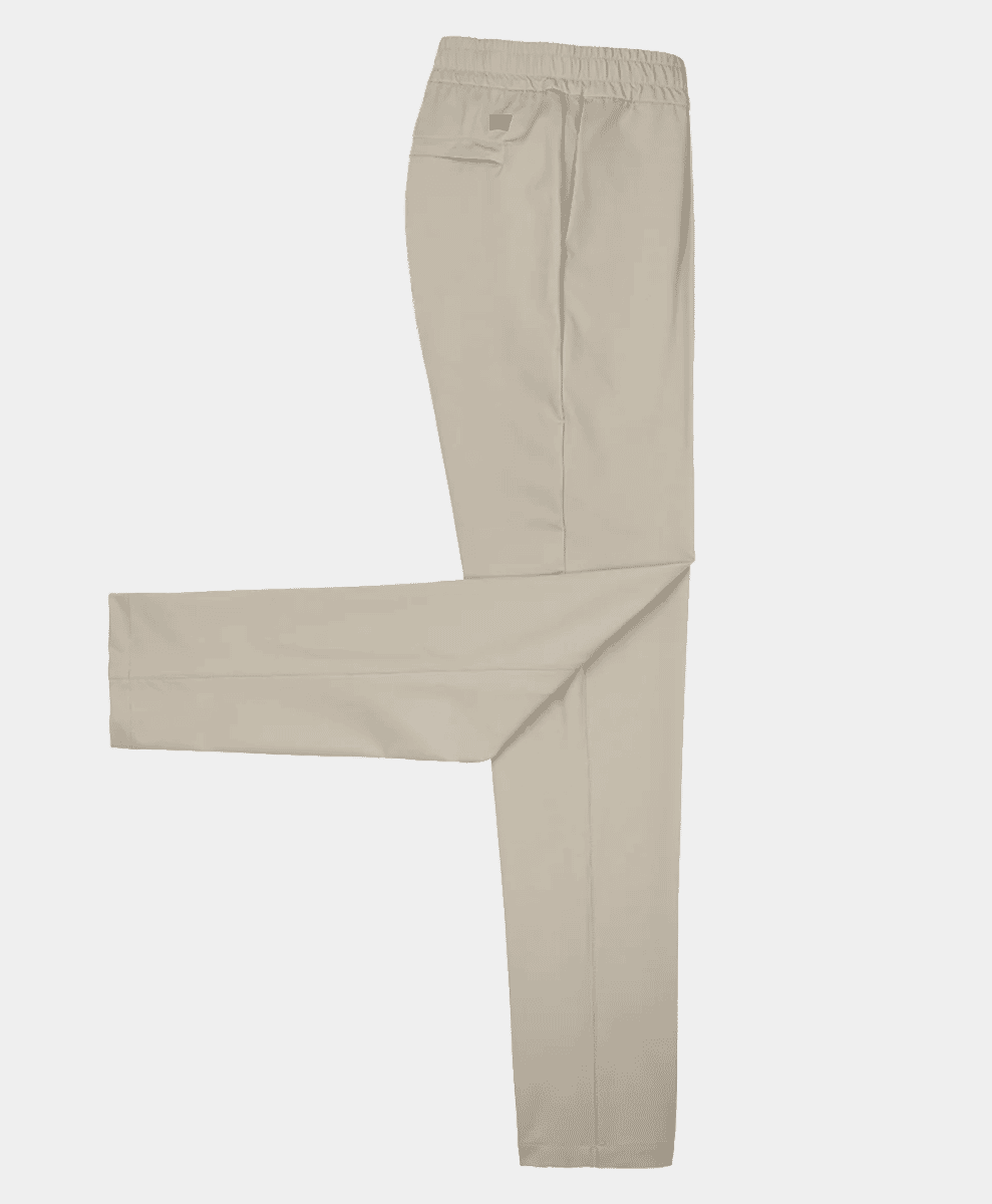 Flat lay of beige stretch trousers with an elastic waist.