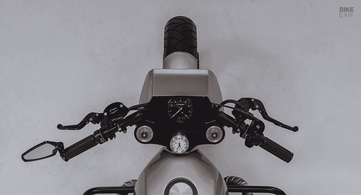 Top-down view of motorcycle handlebars, gauges, and a minimalist dashboard.