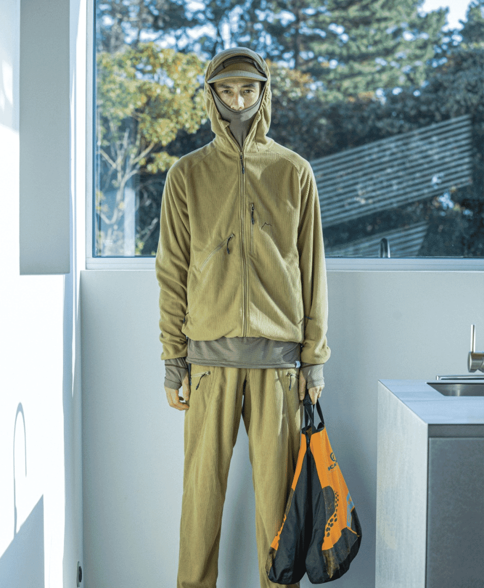 A man wearing a coordinated beige corduroy outdoor jacket and pants