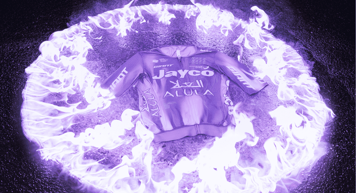 A Jayco Alula cycling jersey centered within a ring of stylized purple flames against a dark background.
