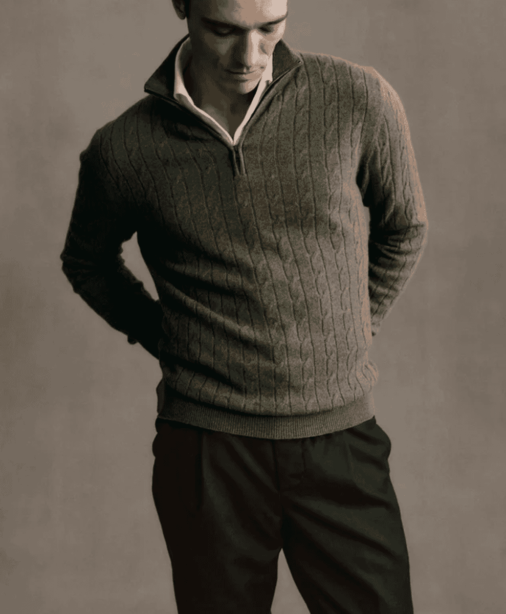Man wearing a brown ribbed cable-knit quarter-zip sweater over a white shirt.