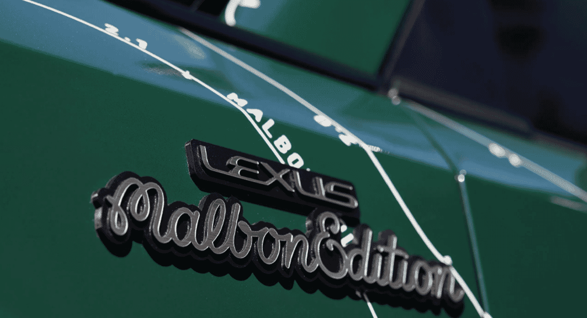 Close-up detail of the chrome Lexus Malbon Edition badge on the vehicle's green exterior.