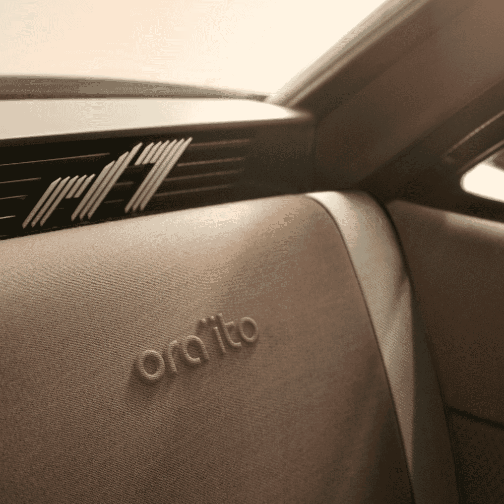 Close-up of beige textured car seat with 'ora'ito' embossed branding.