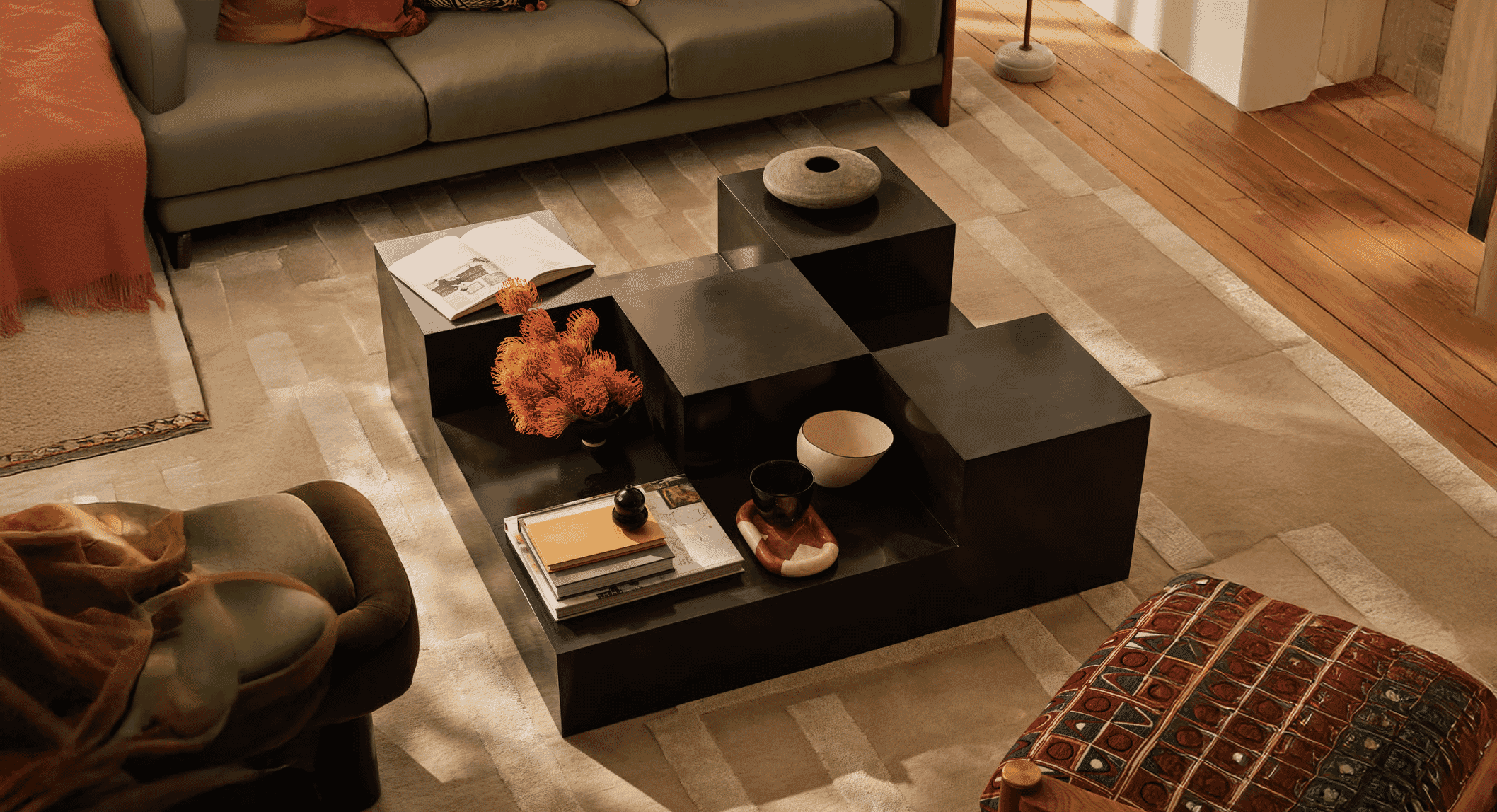A black geometric coffee table serving as a centerpiece in a modern living room.