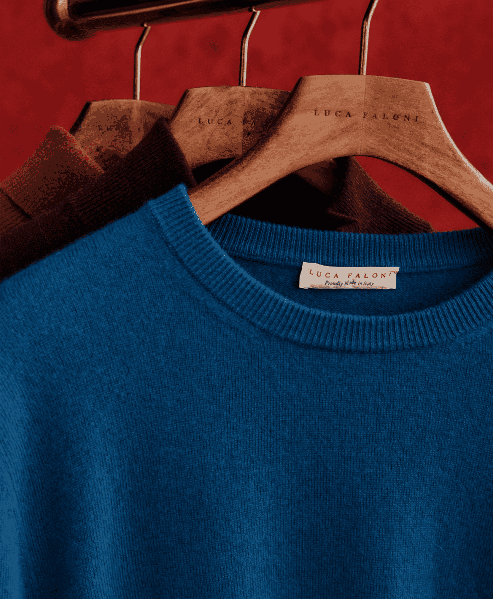 Close-up of a 'Proudly Made in Italy' label on a blue Luca Faloni crew neck sweater.