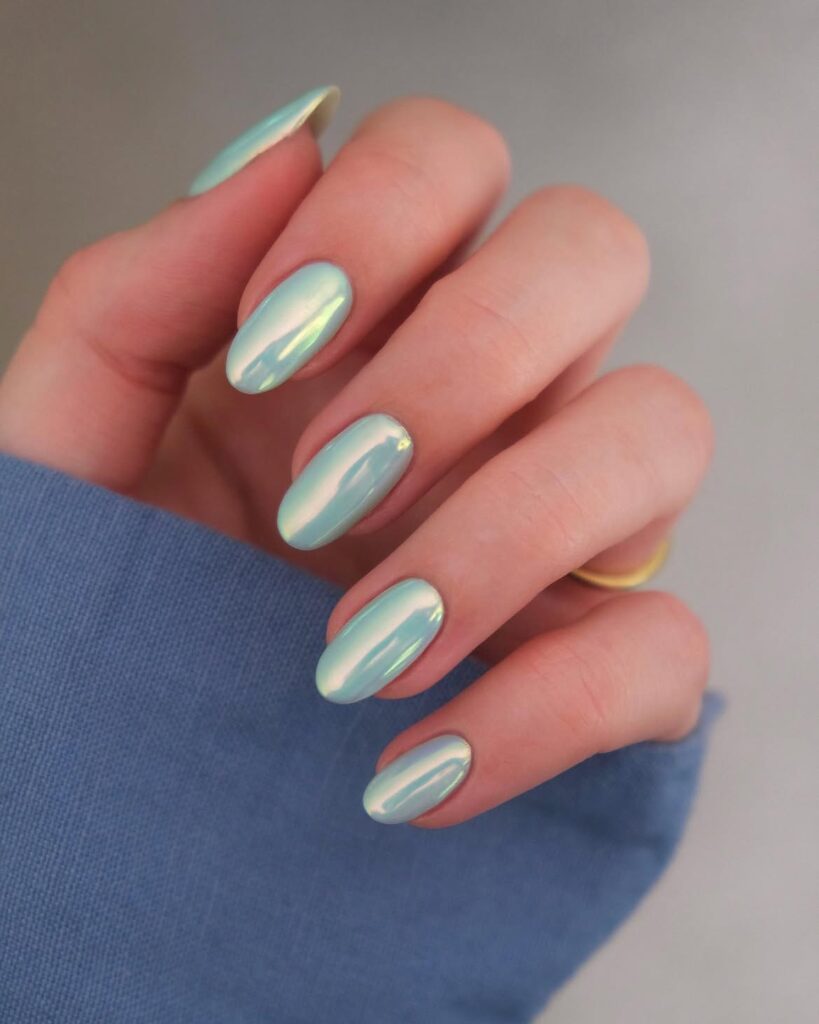 Close-up of color-shifting green and blue mermaid chrome nails.