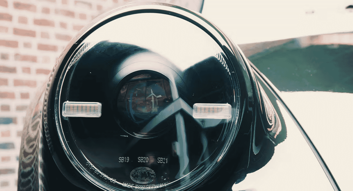 Extreme close-up of a vintage car headlight with a reflective chrome housing.