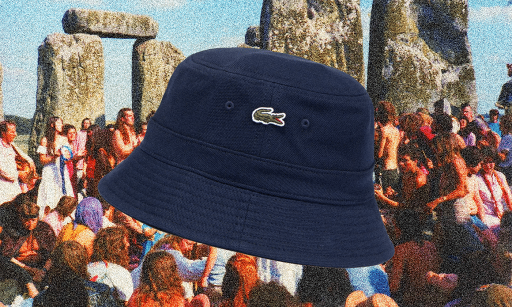 Navy blue Lacoste bucket hat with the crocodile logo shown over a vintage-style festival crowd at Stonehenge.