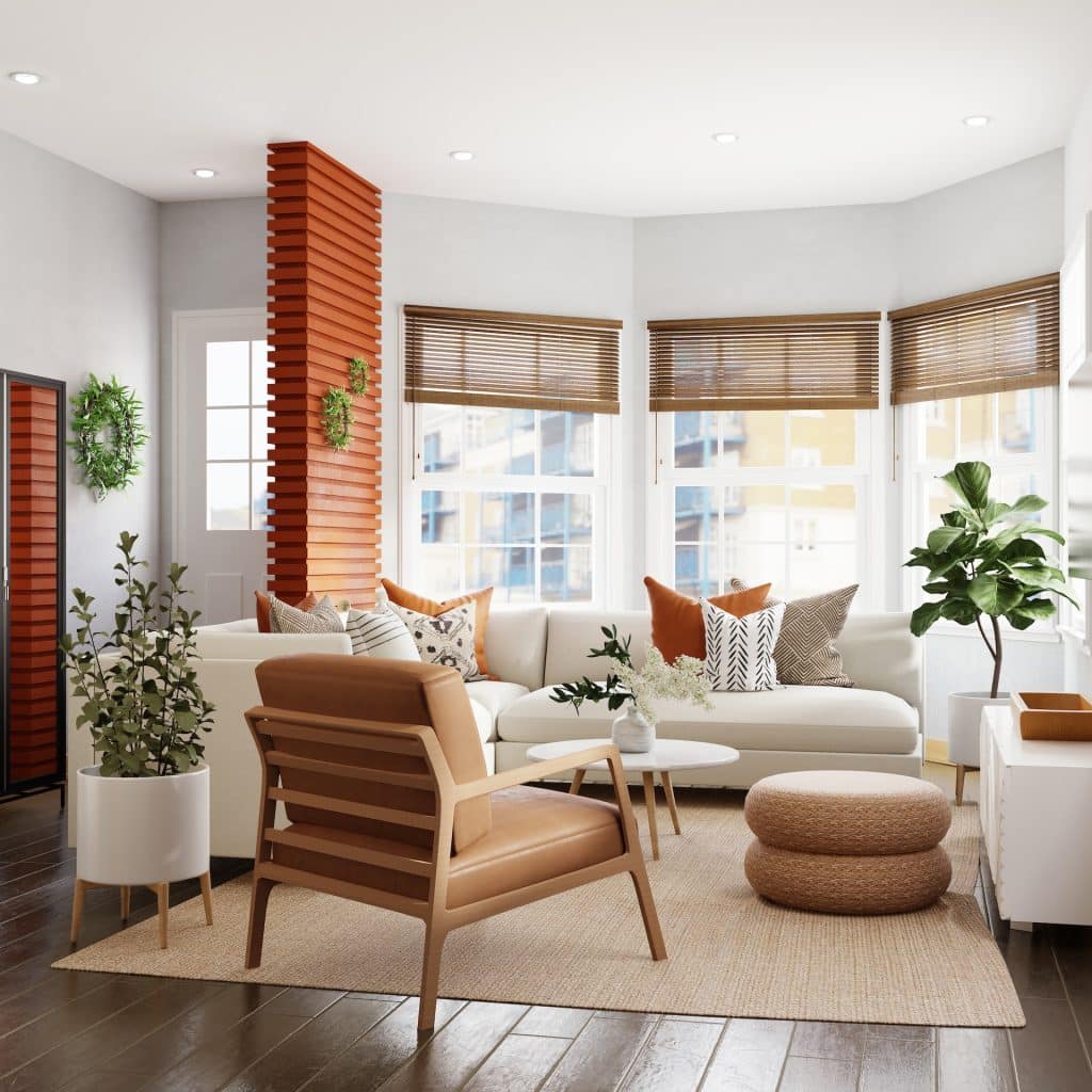 Living room with white sectional sofa, orange pillows, and a woven ottoman.