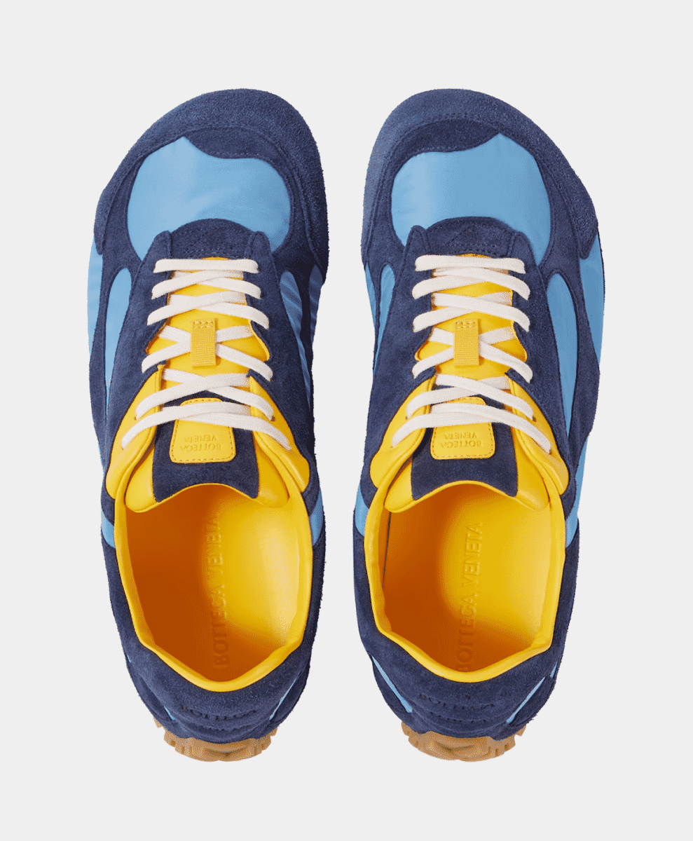 Top-down view of navy, light blue, and yellow Bottega Veneta Orbit Flash sneakers.