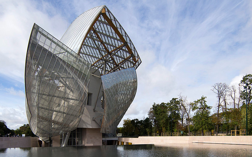 The Musée du Quai Branly in Paris, a striking modern building with glass and steel curves reflected in water, set against trees under a partly cloudy sky.