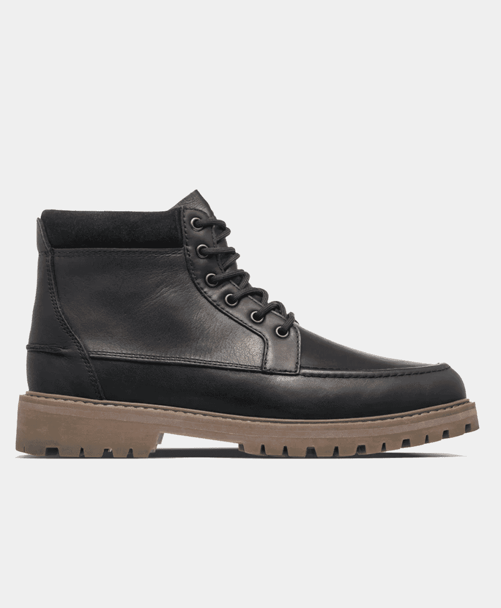 Profile of a men's black leather lace-up boot featuring a contrasting tan rubber sole.