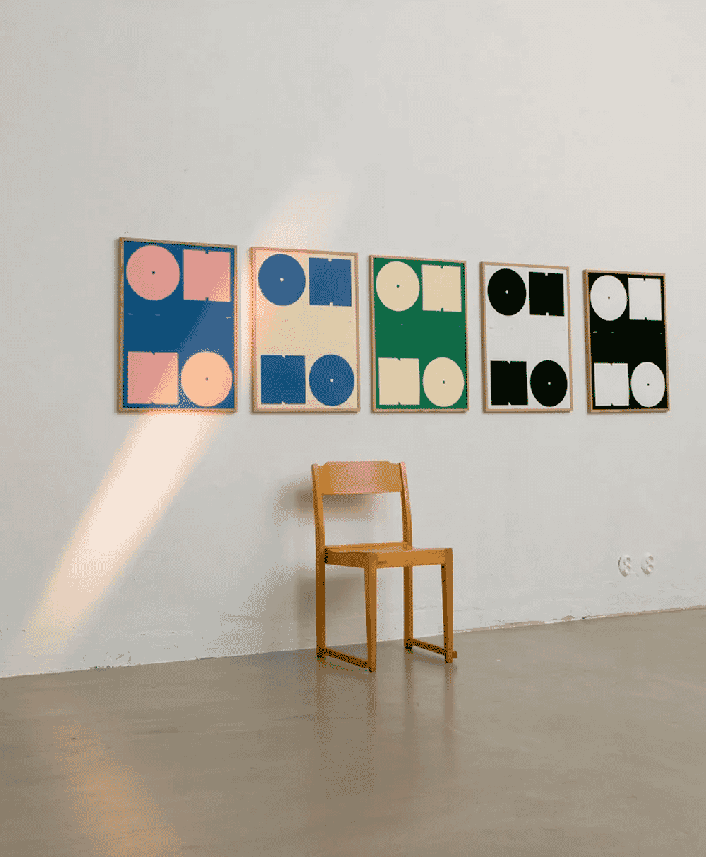 A gallery wall featuring five framed abstract 'OH NO' prints in vibrant yellow, green, and red hues.