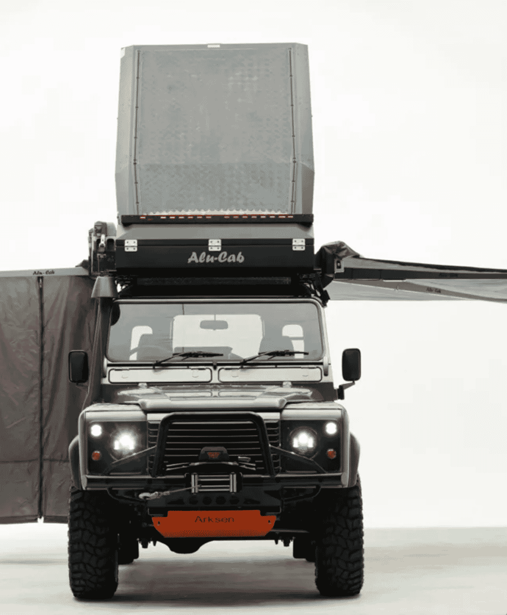 A color photo of an Arksen-branded off-road vehicle with an open rooftop tent and awnings.