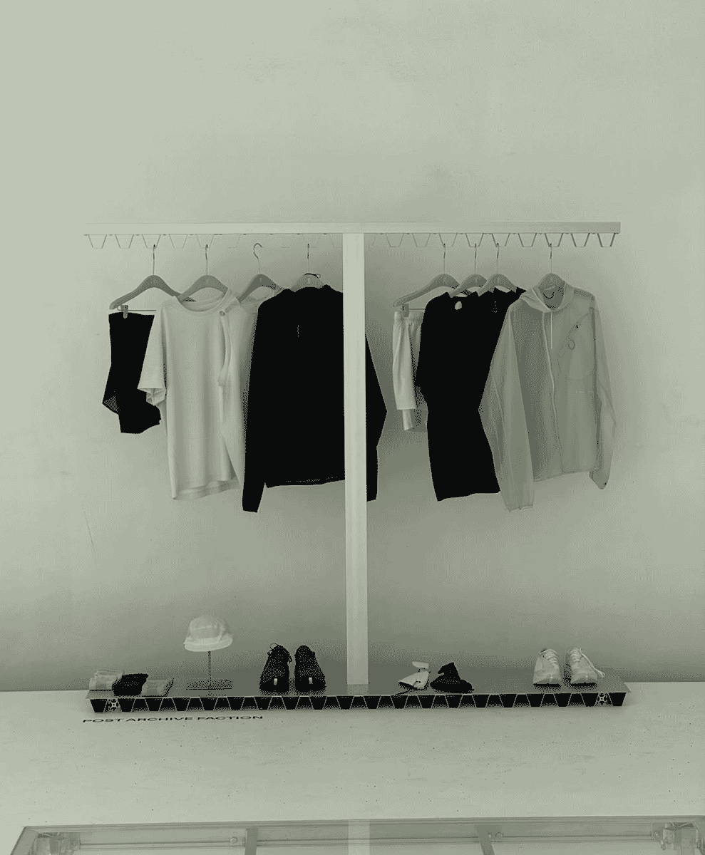 Gender-neutral monochrome apparel on racks labeled POST ARCHIVE FACTION.