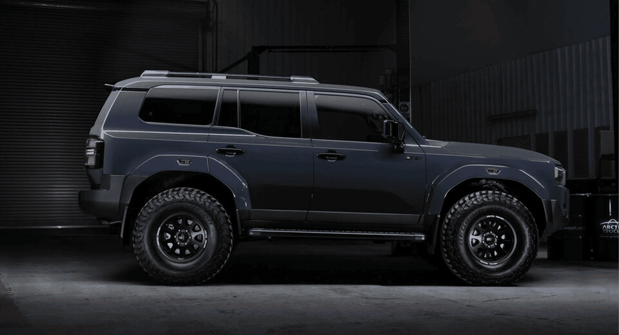 A dark gray off-road SUV showing significant ground clearance and heavy-duty utility design.