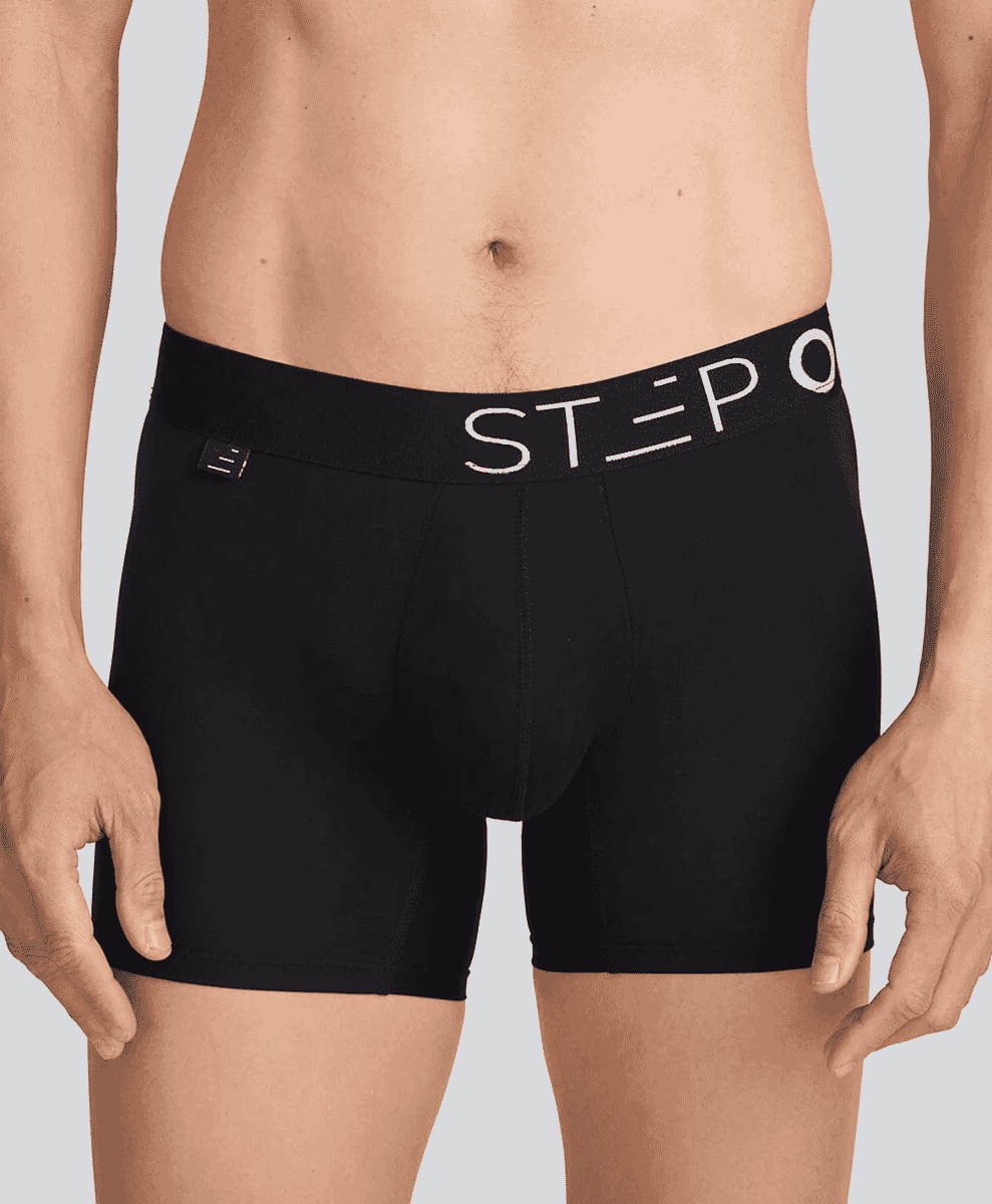 Clean studio shot of a model wearing black fitted Step brand boxer briefs with a white logo waistband.