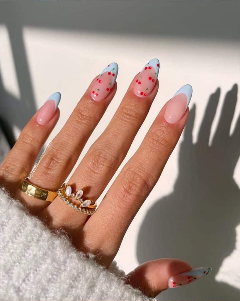 Pastel cherry nail art showcased against a white fuzzy sweater in bright sunlight.