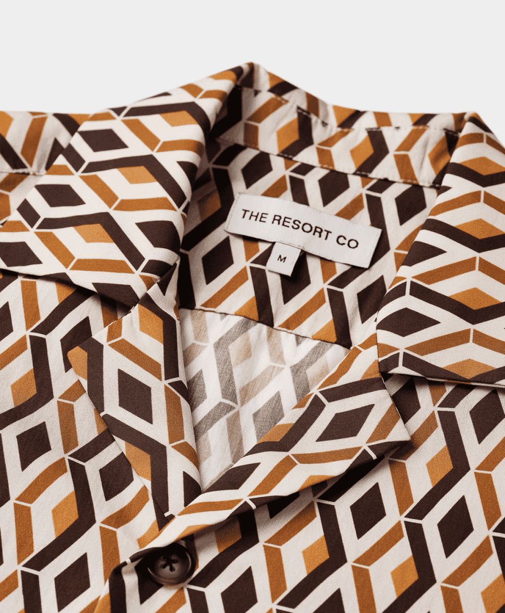 Close-up of 'The Resort Co' label on a geometric 3D cube pattern shirt.
