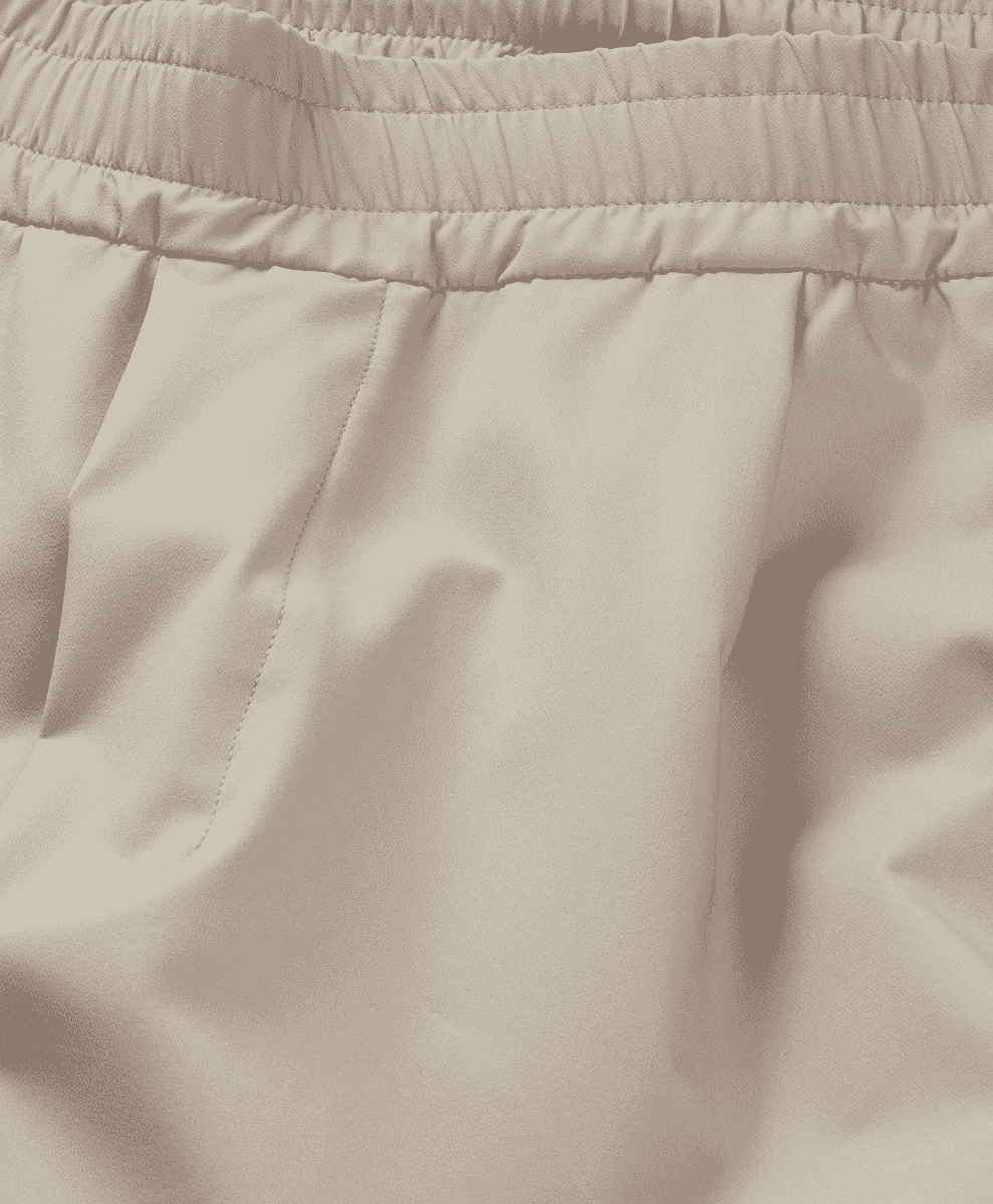 Close-up of a beige elastic waistband on soft, textured fabric.