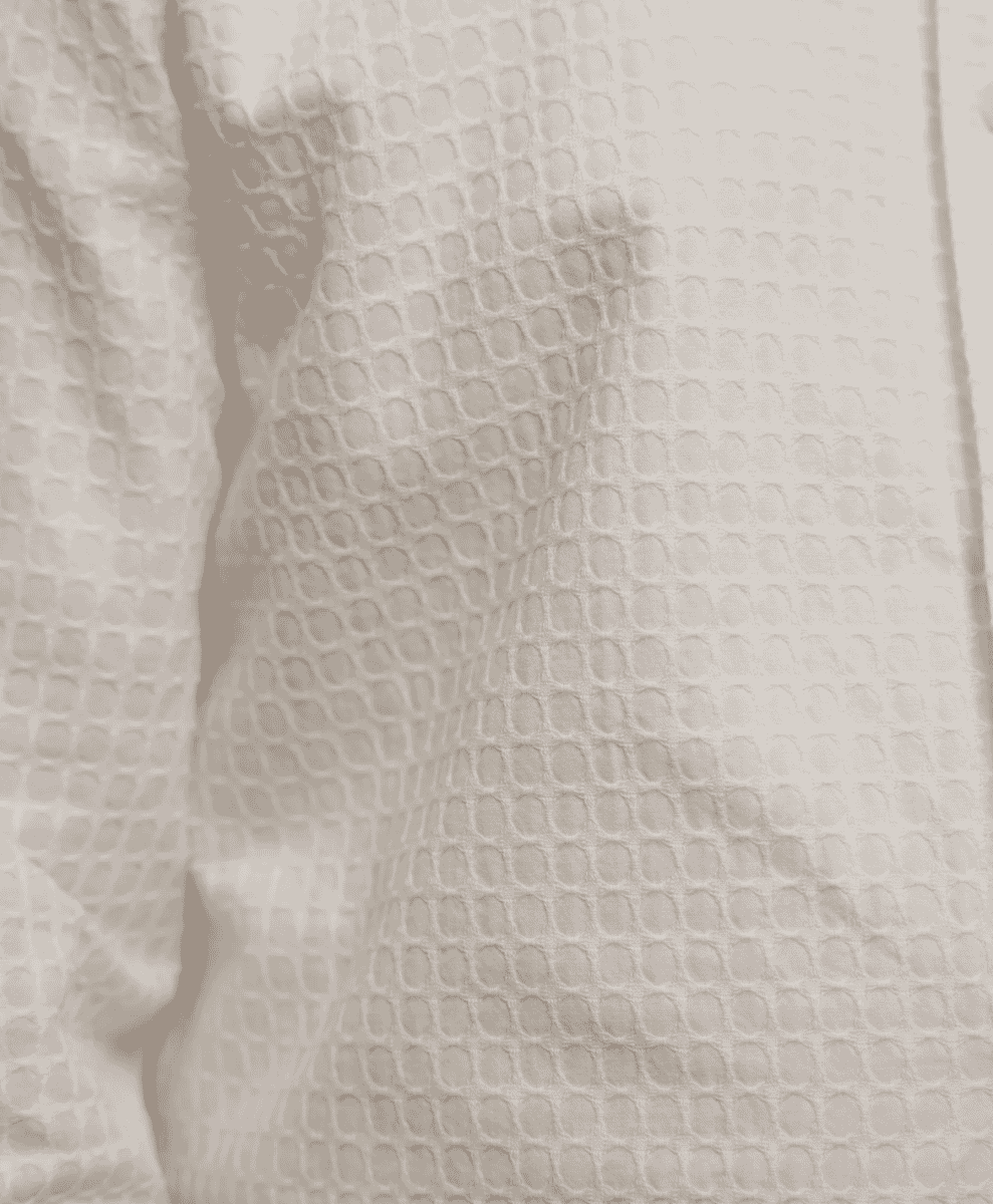 Close-up of a cream-colored honeycomb textured fabric.