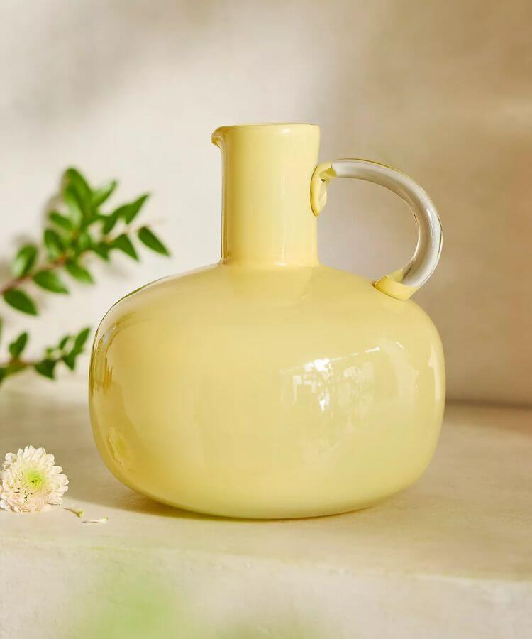 Clear yellow glass vase with a small handle.