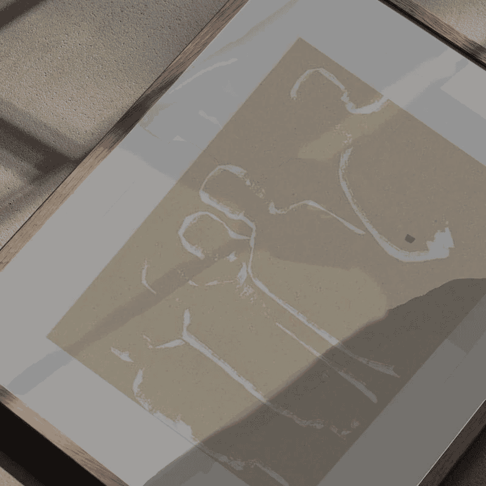A framed abstract beige brushstroke pattern on heavily textured paper.