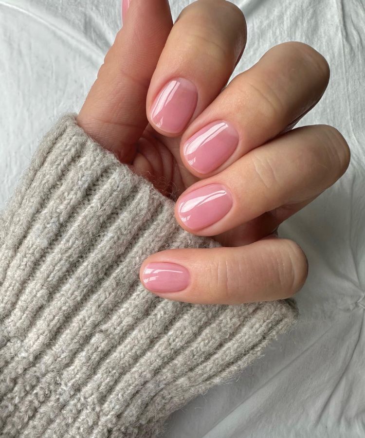 Almond-shaped nails with a translucent blood-orange gradient polish and high-gloss finish.