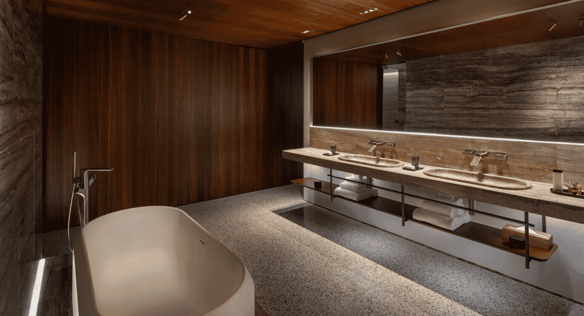 Modern luxury bathroom in the Darsena Suite with warm wooden walls and a minimalist freestanding bathtub.
