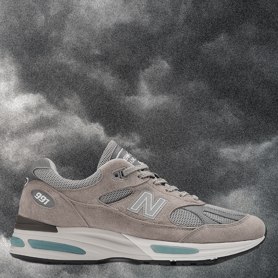 Gray suede New Balance 991 with teal accents and mesh details.
