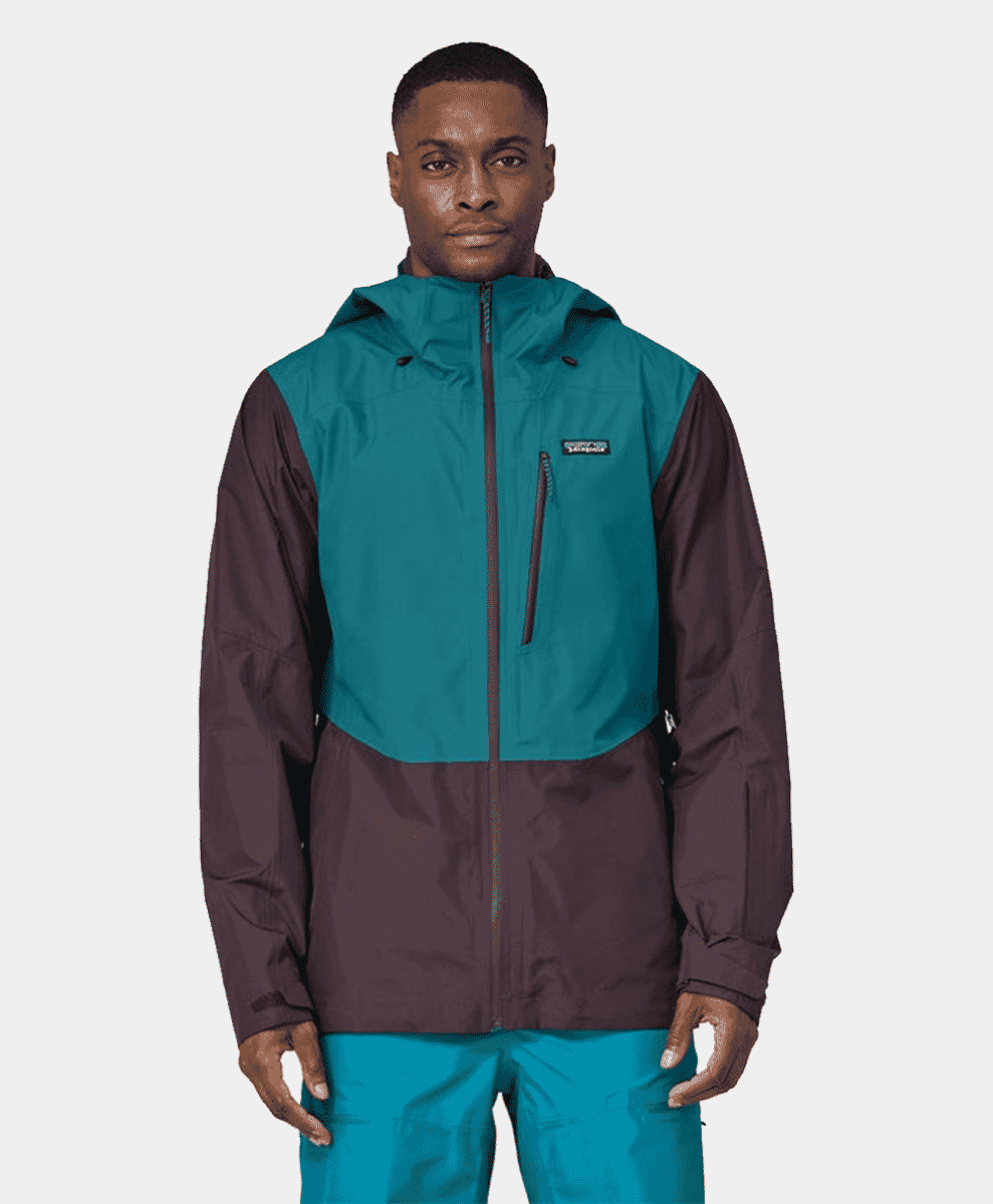 Man wearing a two-tone teal and dark brown Patagonia technical ski jacket.