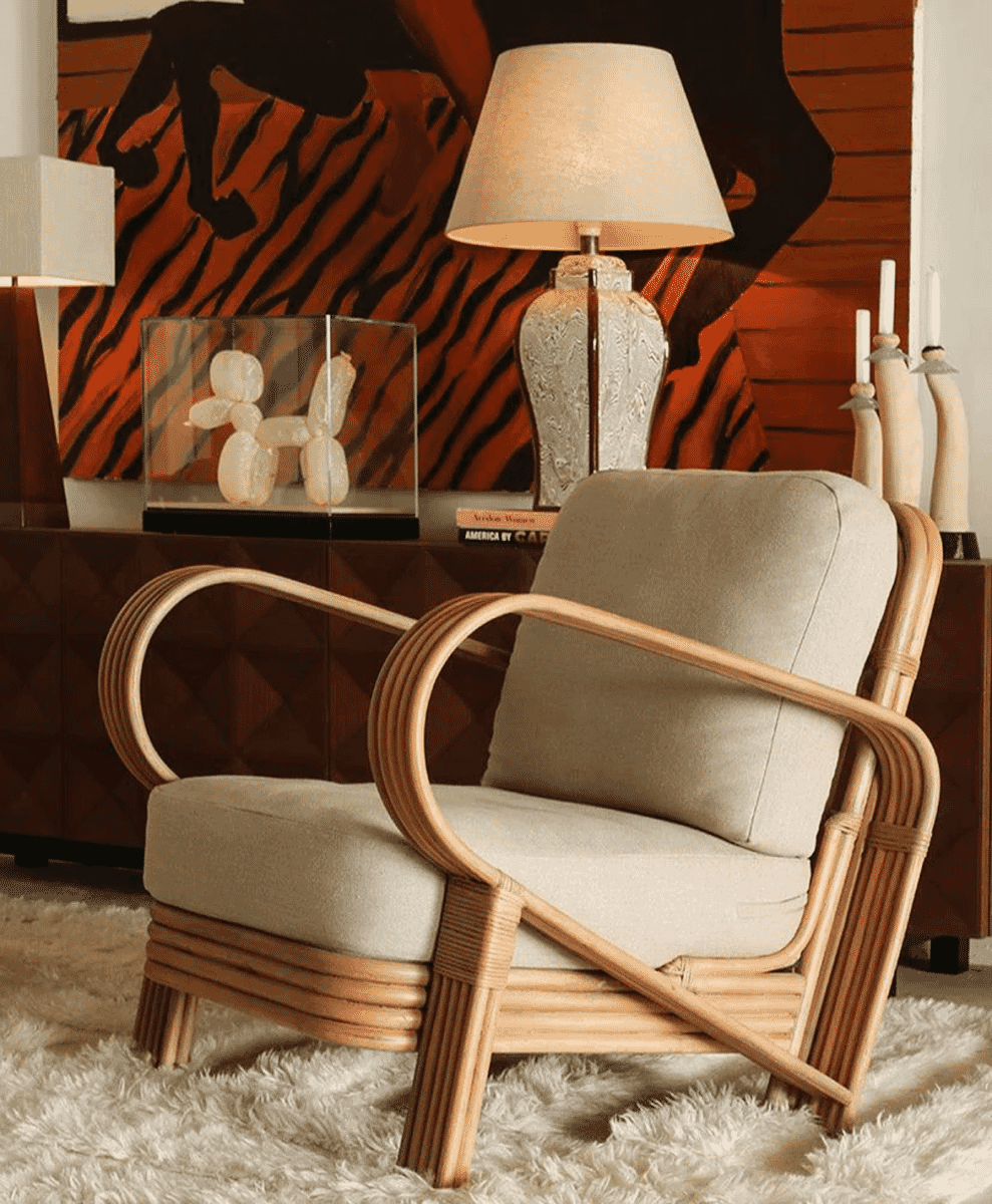 Mid-century modern rattan lounge chair with beige upholstery on a white rug.