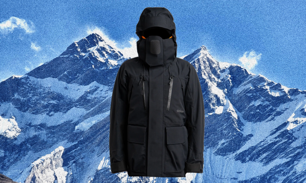 A person in a black high-performance technical jacket with an integrated hood and face mask.