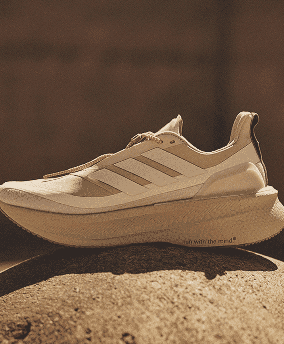 Sole of a beige Adidas shoe featuring the phrase 'run with the mind'.