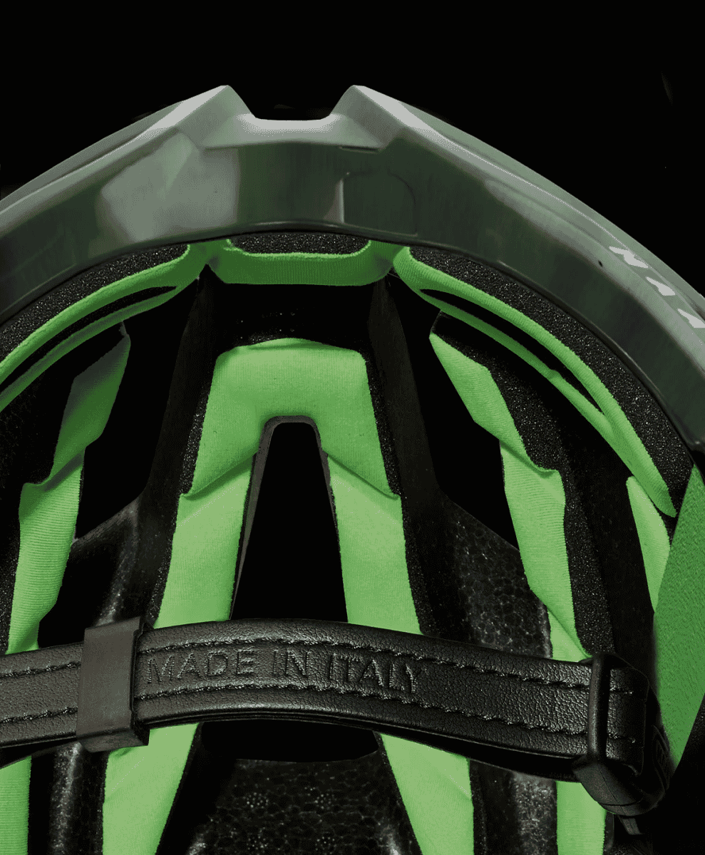 Interior view of a cycling helmet showing bright green 3D DRY padding and a 'MADE IN ITALY' embossed leather strap.