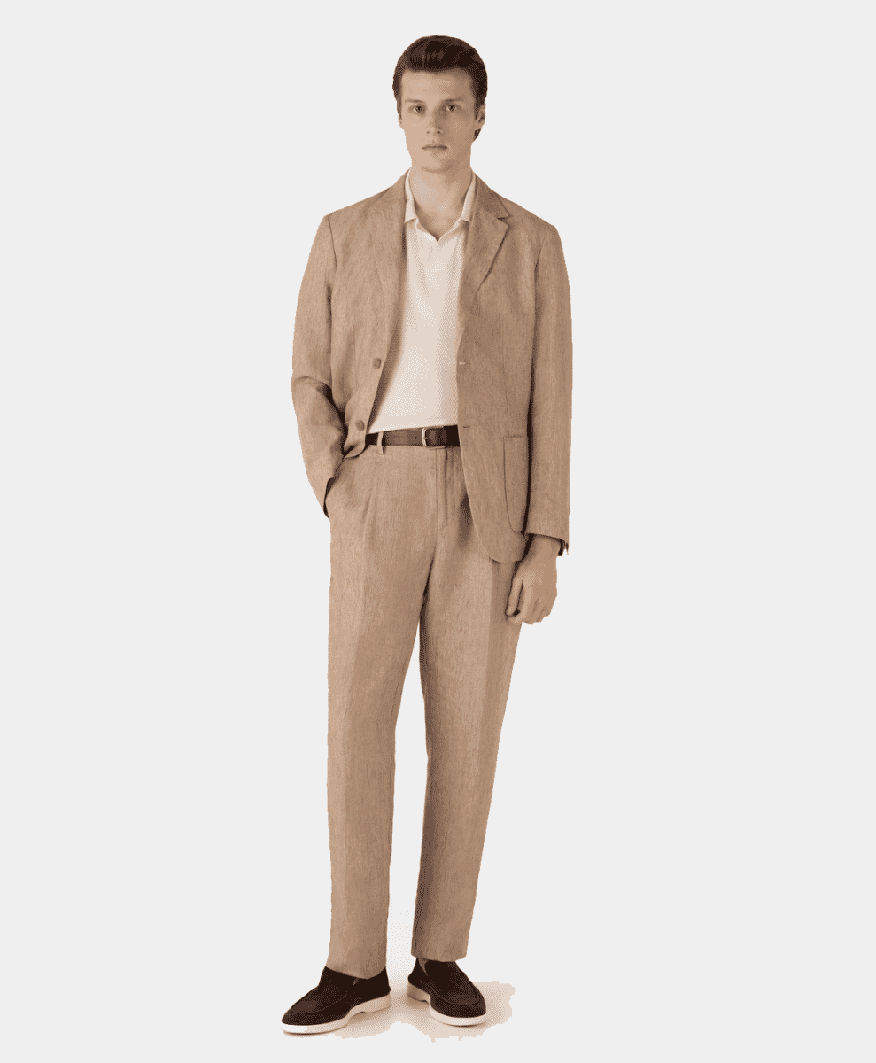A man models a beige linen suit paired with a white polo shirt and loafers.