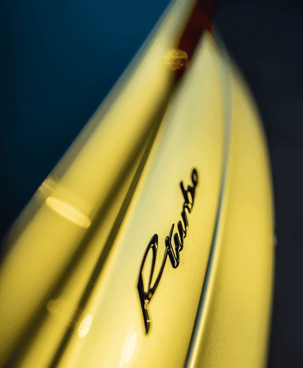 Close-up of a golden 'Turbo' emblem on a dark car body.