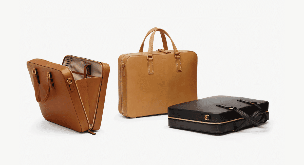 Three leather briefcases in various shades of brown and black displayed together.