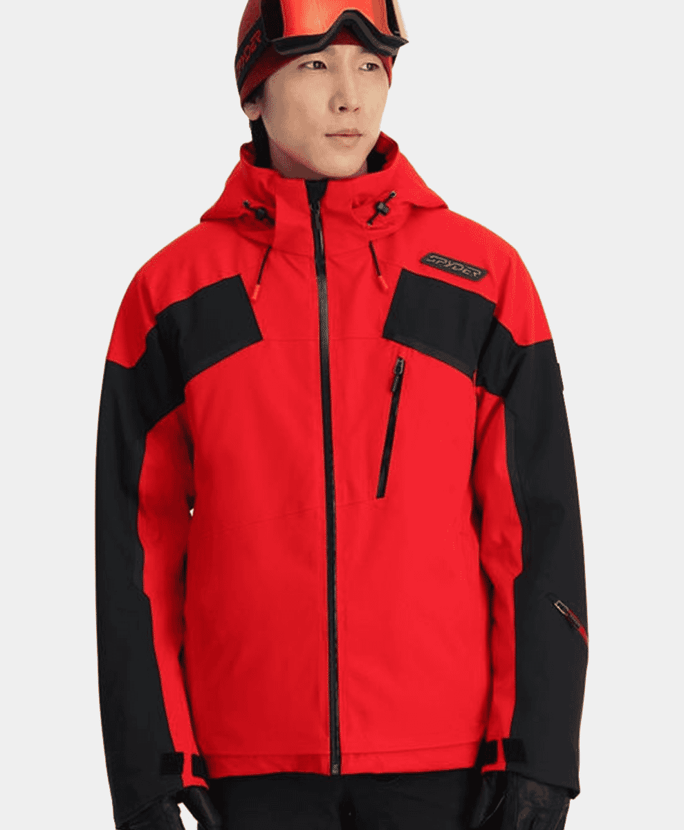 A man modeling a vibrant red and black Spyder ski jacket with matching accessories.