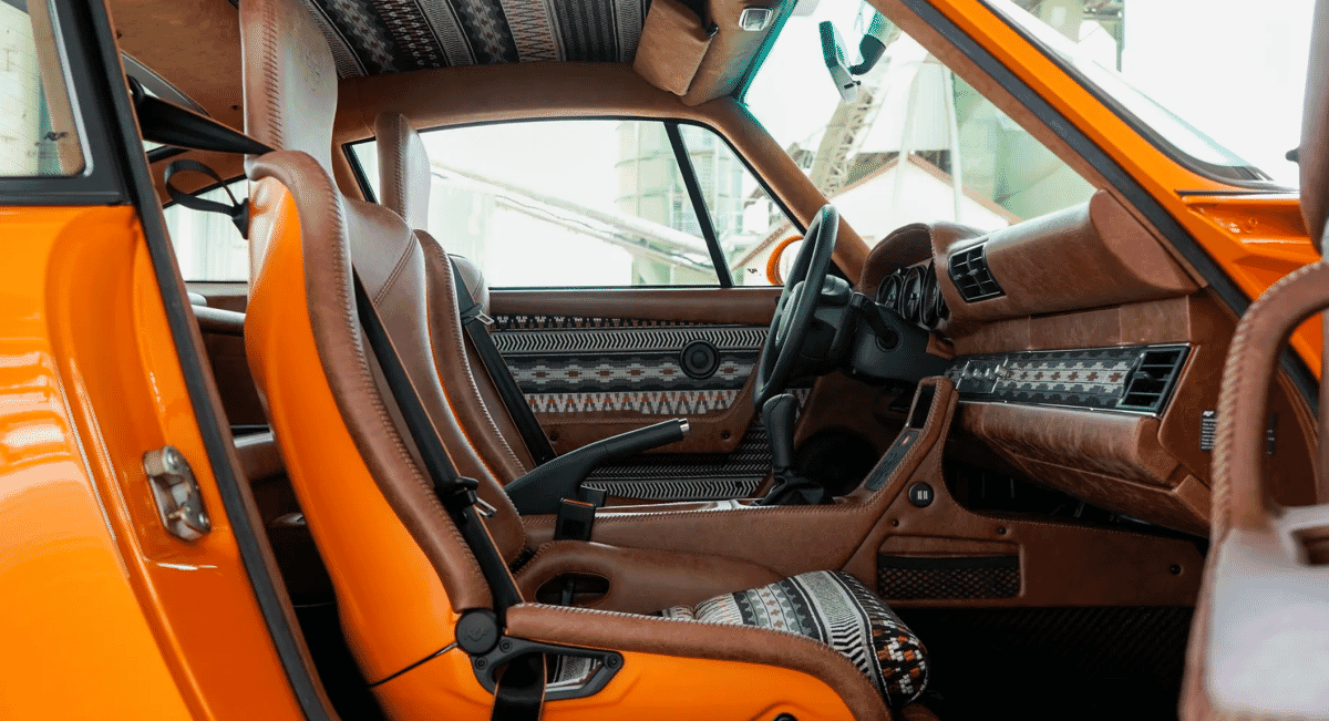 Interior of a custom sports car with brown leather seats and southwestern patterned fabric inserts.