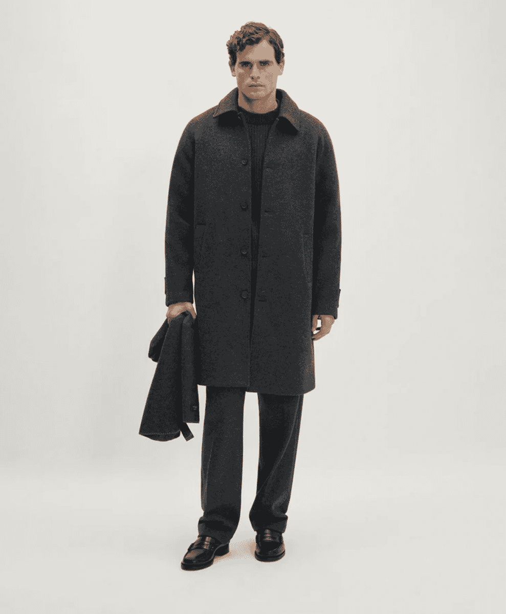 A man in a charcoal wool coat and a black ribbed turtleneck sweater.