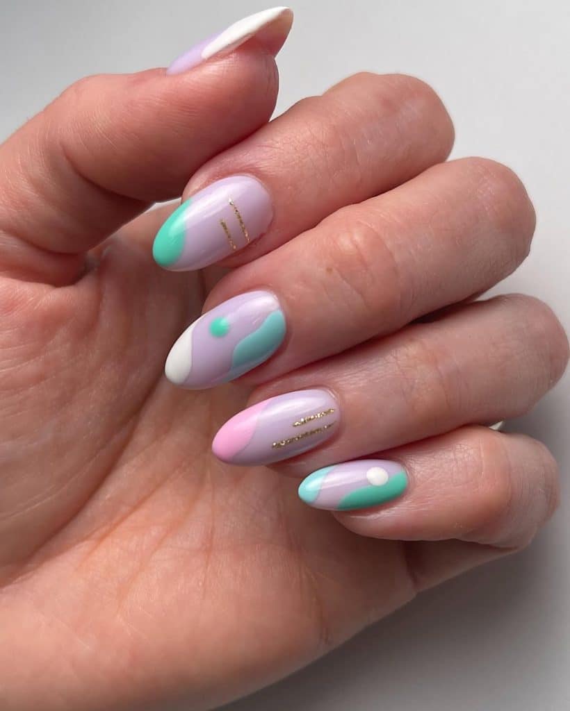 Abstract pastel nail art with lavender, mint, and white accented by gold lines.