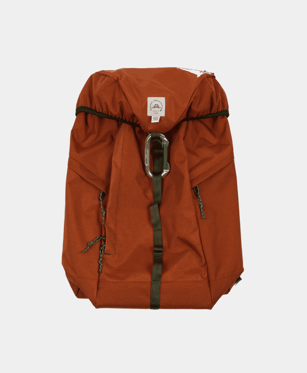 Rust-orange Epperson Mountaineering backpack with green straps and a metal carabiner.
